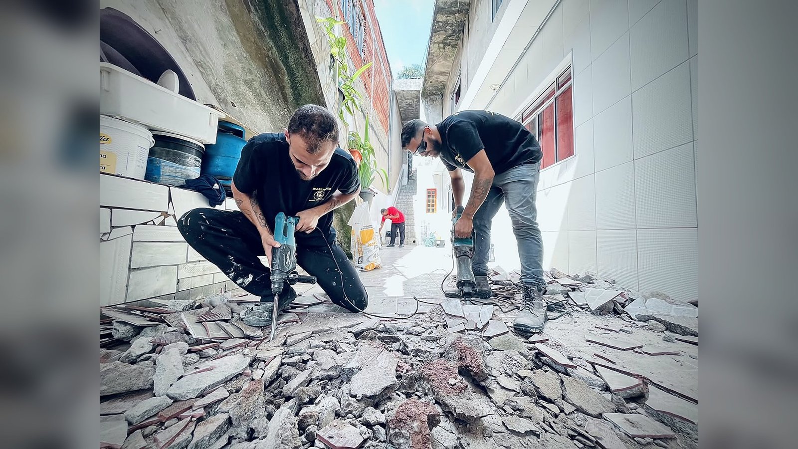 Dois colaboradores da Bom Service trabalhando com marteletes em uma obra