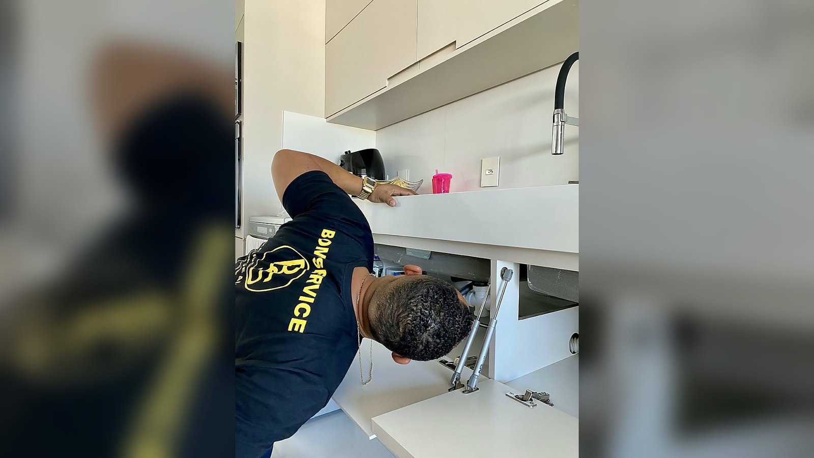 Colaborador da Bom Service verificando a parte inferior de uma pia