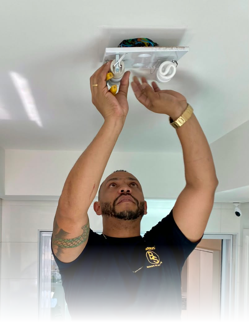 Profissional da Bom Service instalando uma luminária no teto